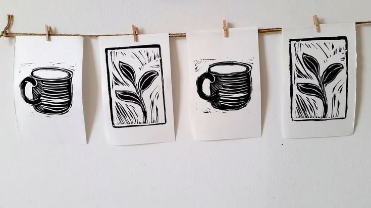 three handmade tea towels hanging on a clothes line with coffee cups and plants drawn on them