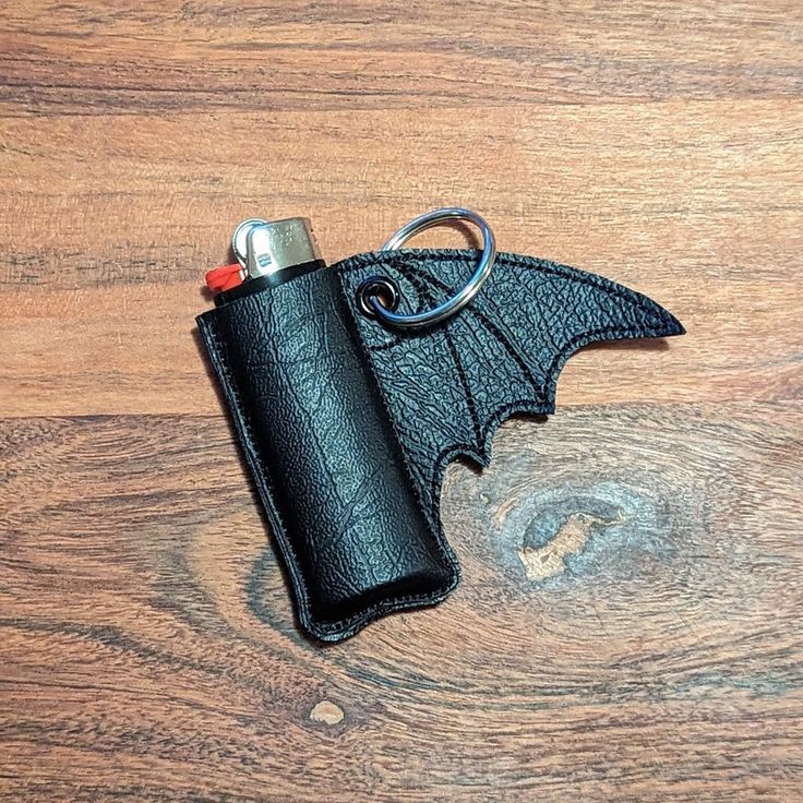 a leather lighter case with a bat design on it