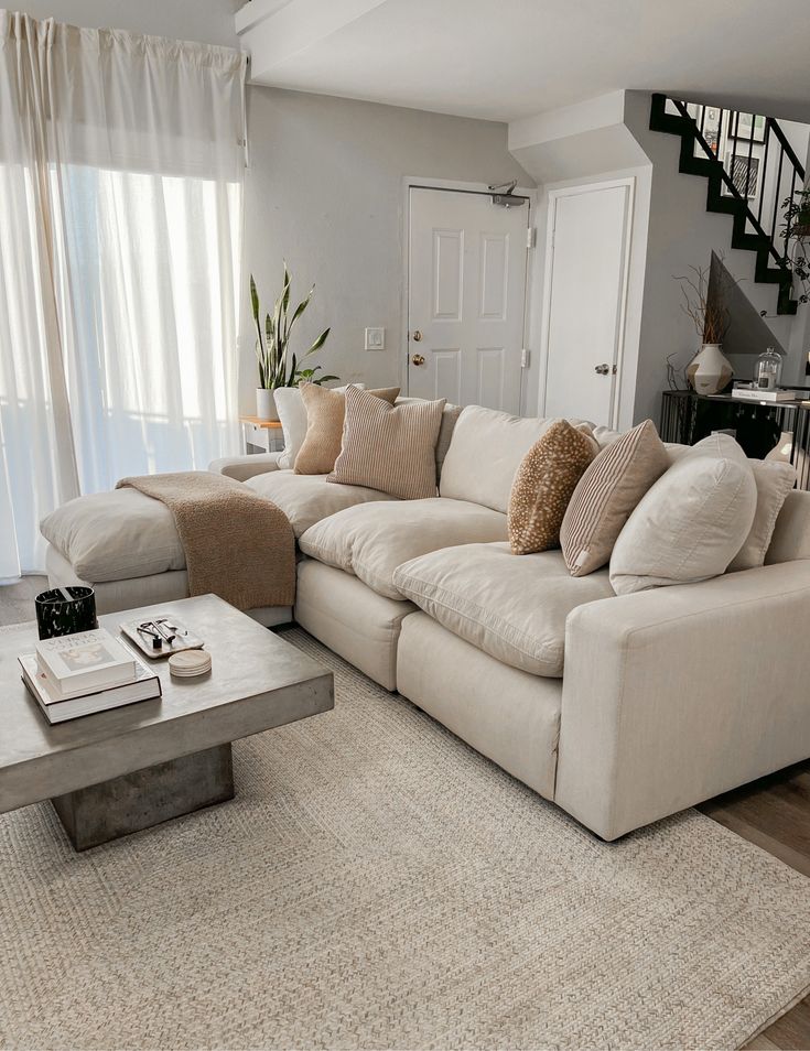 a living room filled with furniture and a stair case in front of the couches