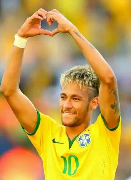 a soccer player with his hands in the shape of a heart and smiling at the camera