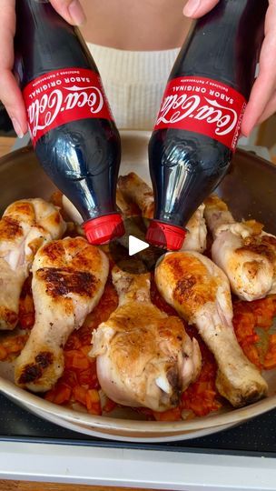 two coca cola bottles are being poured over chicken in a skillet