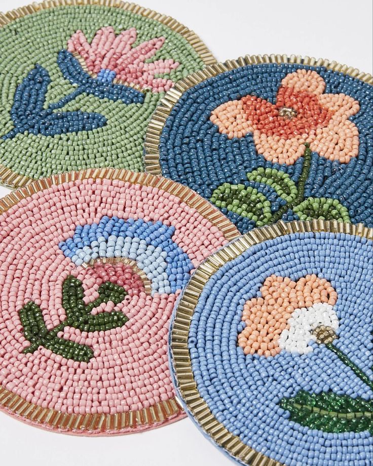 four round beaded coasters with flowers on them