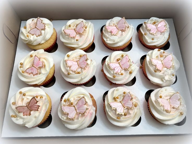 cupcakes with white frosting and pink butterflies on them