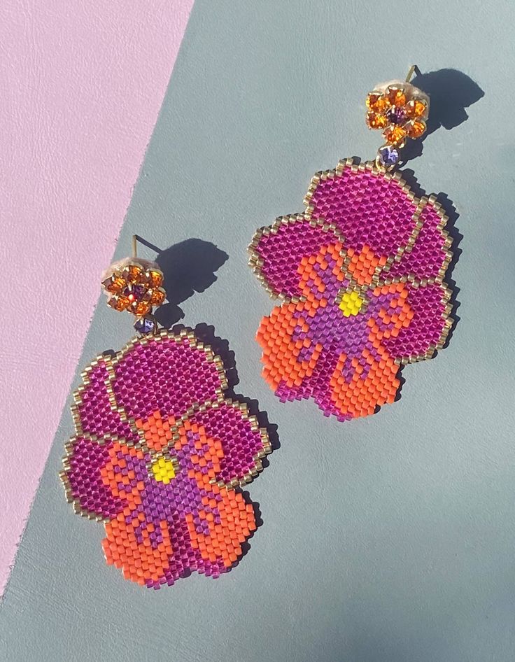 the earrings are made out of bead and have flower designs on each earring