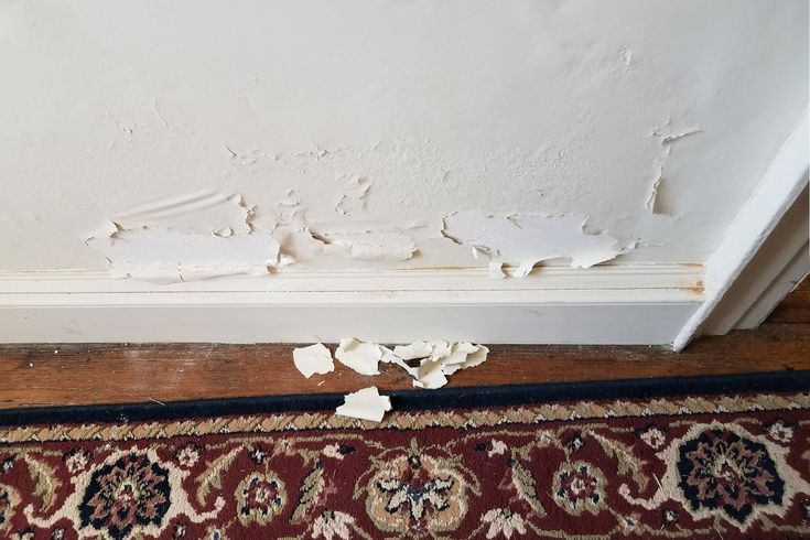 the corner of a room that has been torn off with white paint and chipping