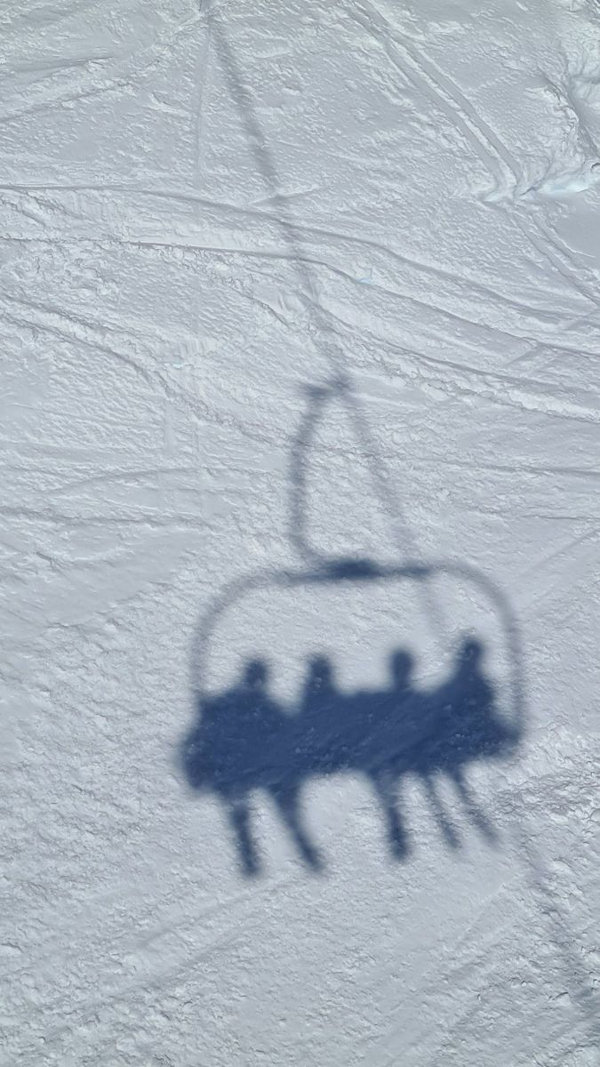 the shadow of a ski lift on snow