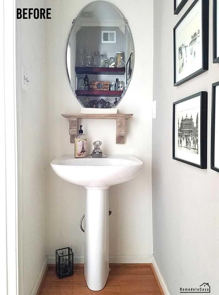 a bathroom sink sitting under a mirror next to a wall with pictures hanging on it