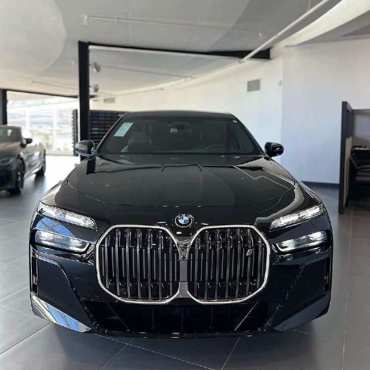 the front end of a black car in a showroom