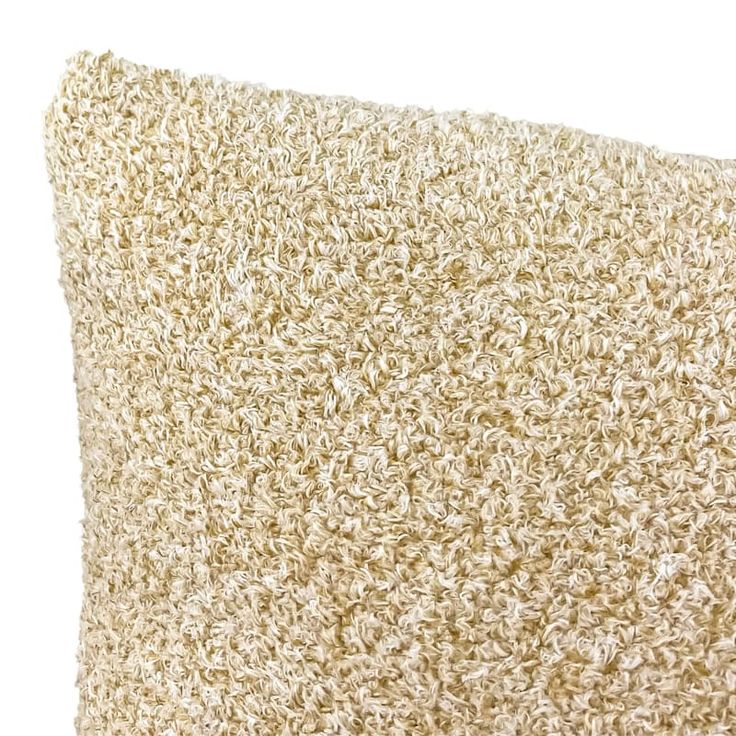 a close up view of a beige pillow on a white background