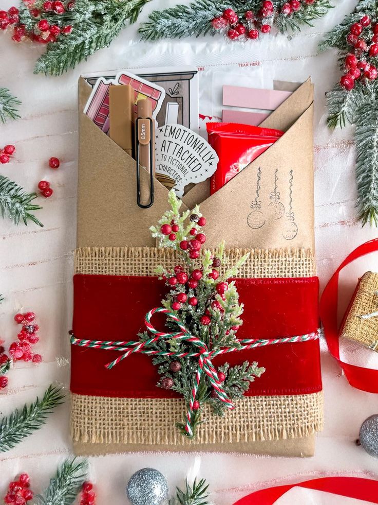 an envelope wrapped in red and brown paper with a christmas tree on it