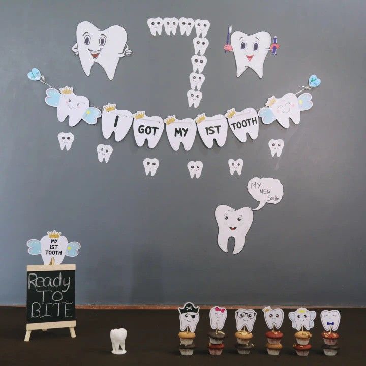 toothpaste cutouts are lined up in front of a chalkboard with the words got my 1st tooth written on it