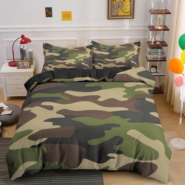 a bed room with a camo print comforter and two pillows on the floor