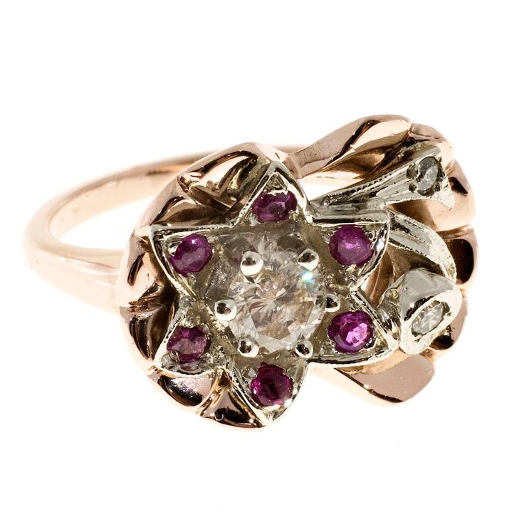 a gold ring with pink and white stones in the shape of a flower, on a white background