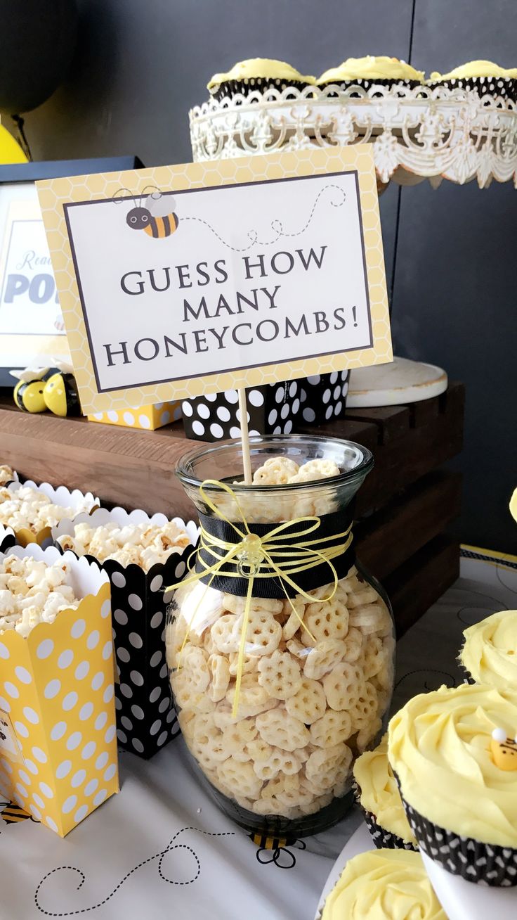 a table topped with lots of cupcakes covered in yellow frosting