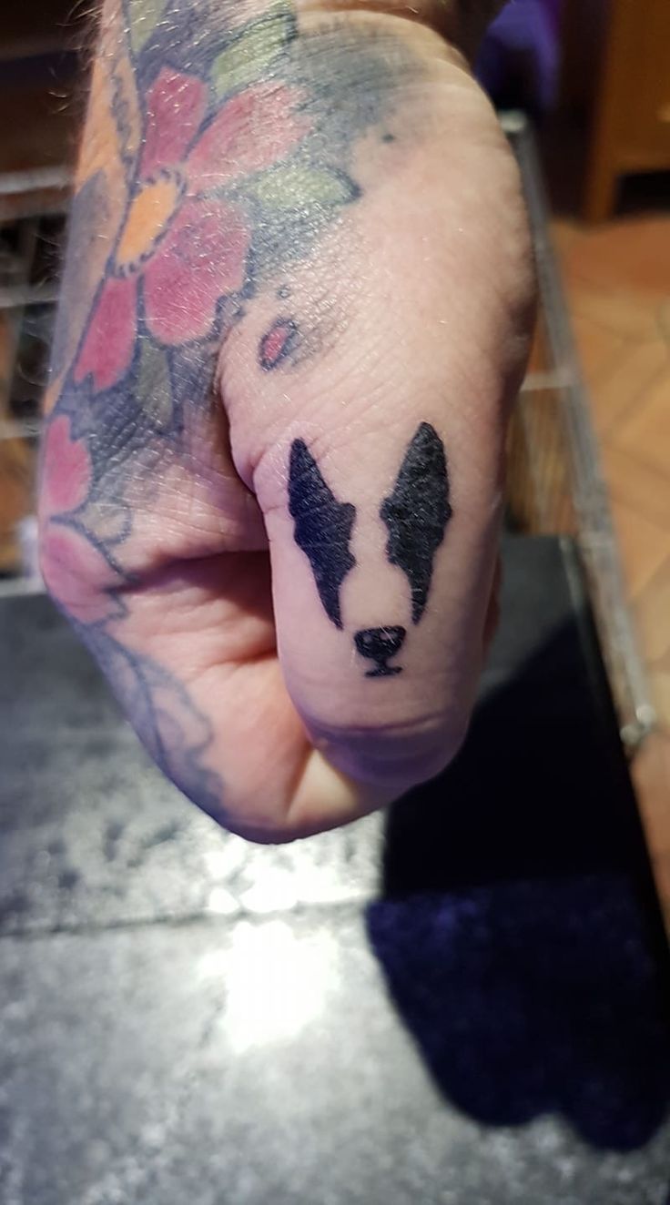 a hand with a dog tattoo on it