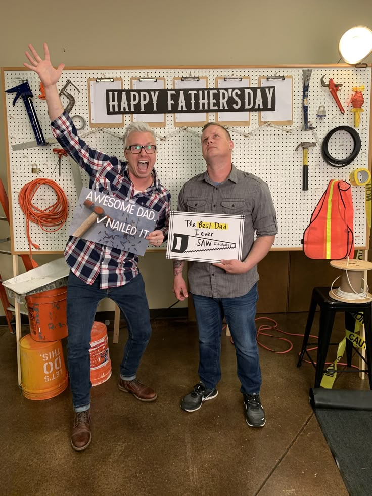 two men standing next to each other holding signs