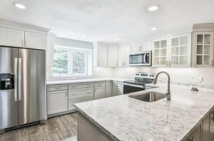 a kitchen with stainless steel appliances and marble counter tops