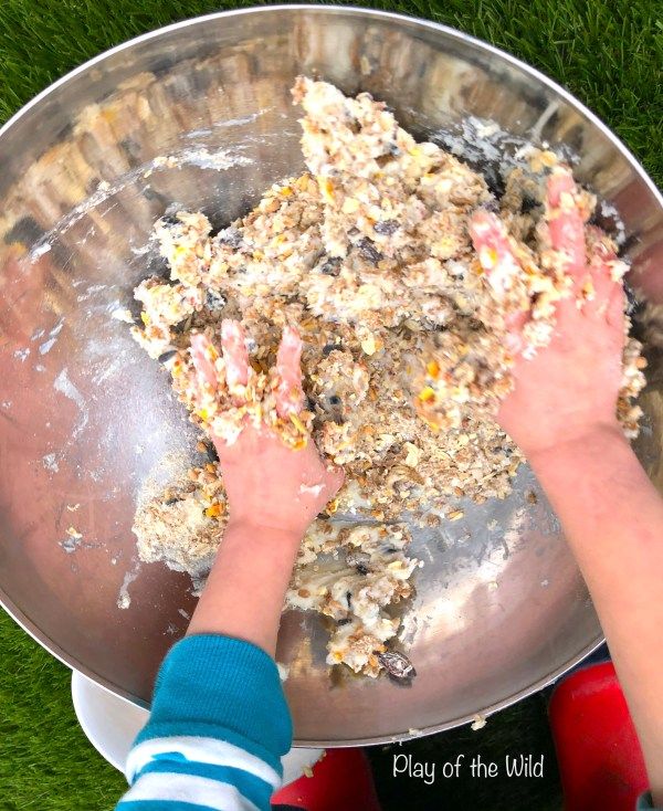 two hands reaching into a metal bowl filled with food