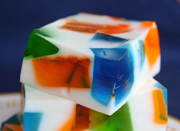 two pieces of colorful soap sitting next to each other on top of a blue surface