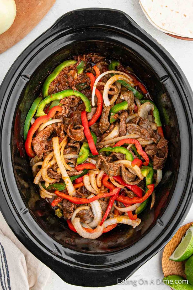 beef fajita in a slow cooker with peppers and onions