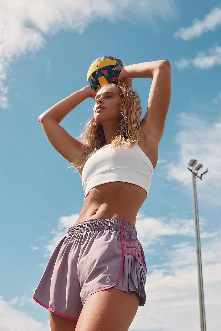 a woman is holding a ball on her head