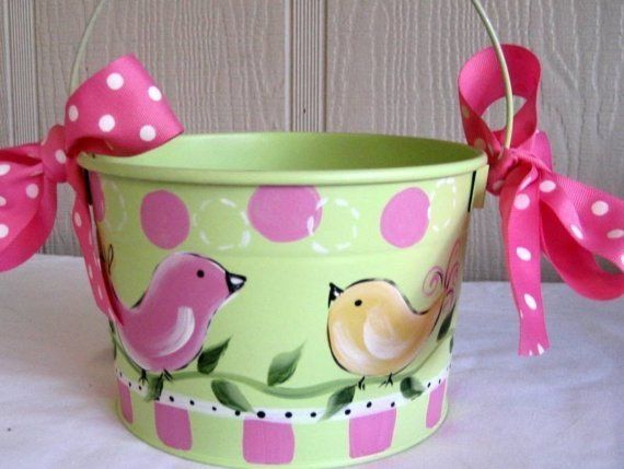 a green bucket with pink polka dots and two little birds on it, tied to the handle