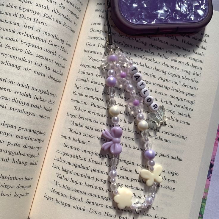 an open book with beads and charms on it