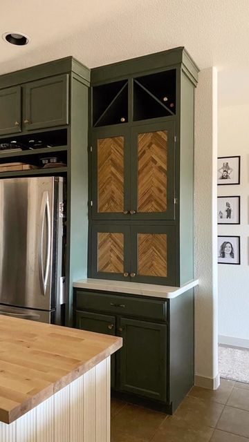 a kitchen with green cabinets and wood counter tops