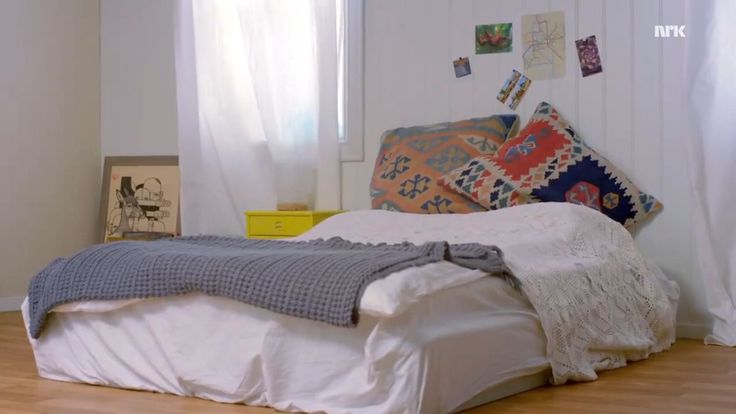 a white bed sitting in a bedroom next to a window