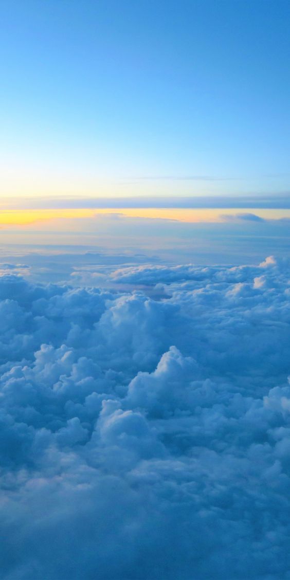 the view from an airplane looking down on clouds