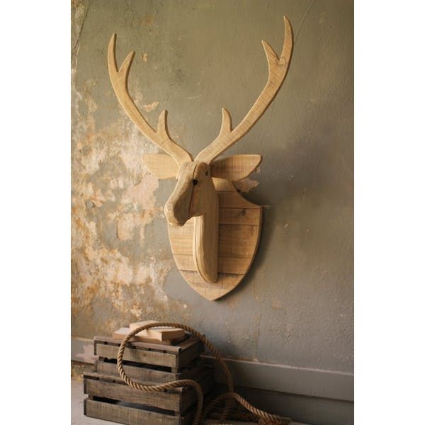 a deer head mounted on the wall next to a pile of wooden crates and baskets