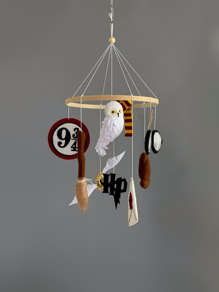 a white bird sitting on top of a wind chime hanging from a ceiling fixture