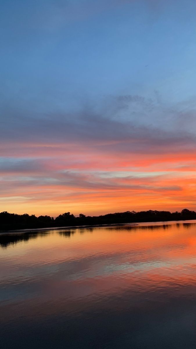 the sky is reflecting in the water at sunset