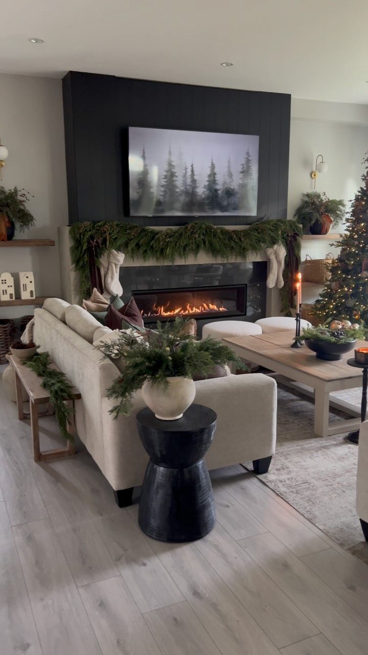 a living room filled with furniture and a fire place in front of a christmas tree