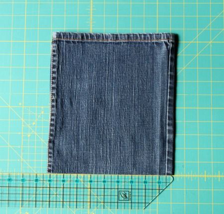 a pair of jeans sitting on top of a cutting board next to a piece of cloth