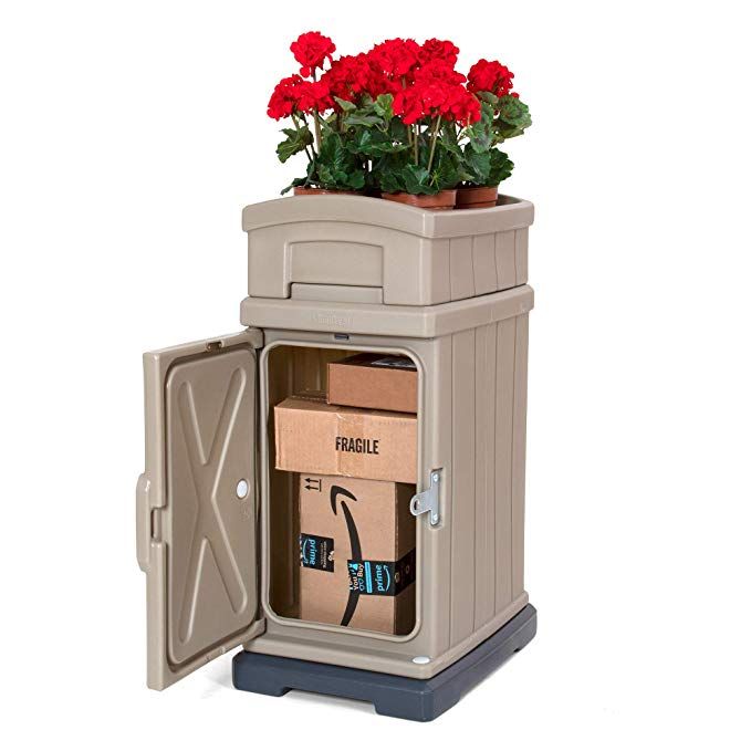 a planter with red flowers in it sitting on top of a carton filled with boxes