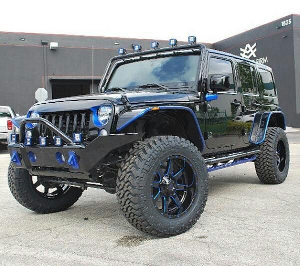 a black and blue jeep parked in front of a building