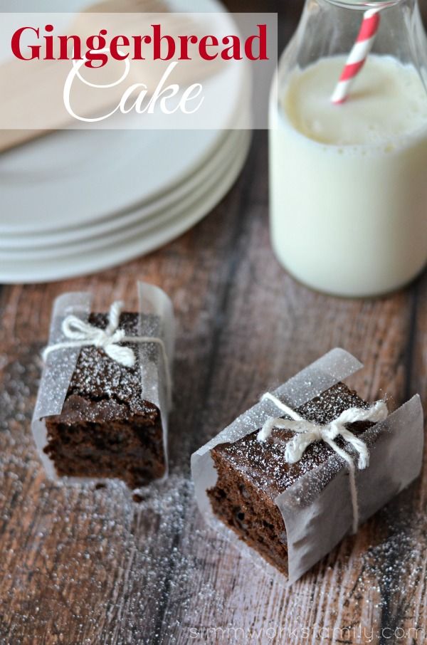 two pieces of cake sitting on top of a wooden table next to a glass of milk