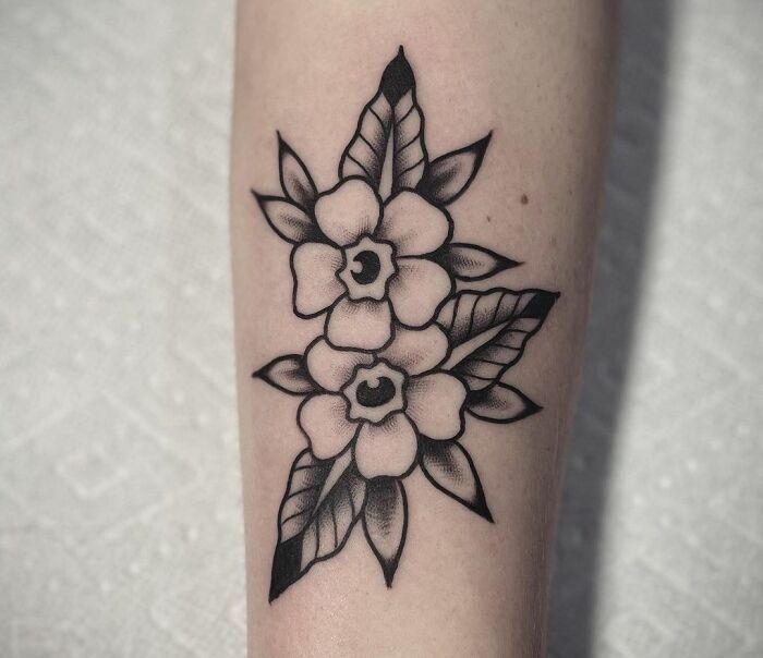 a black and white flower tattoo on the leg