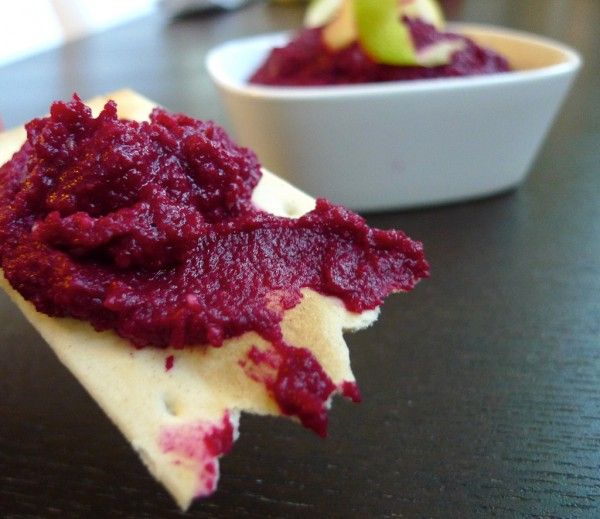 a piece of food that is sitting on a table next to a bowl of fruit