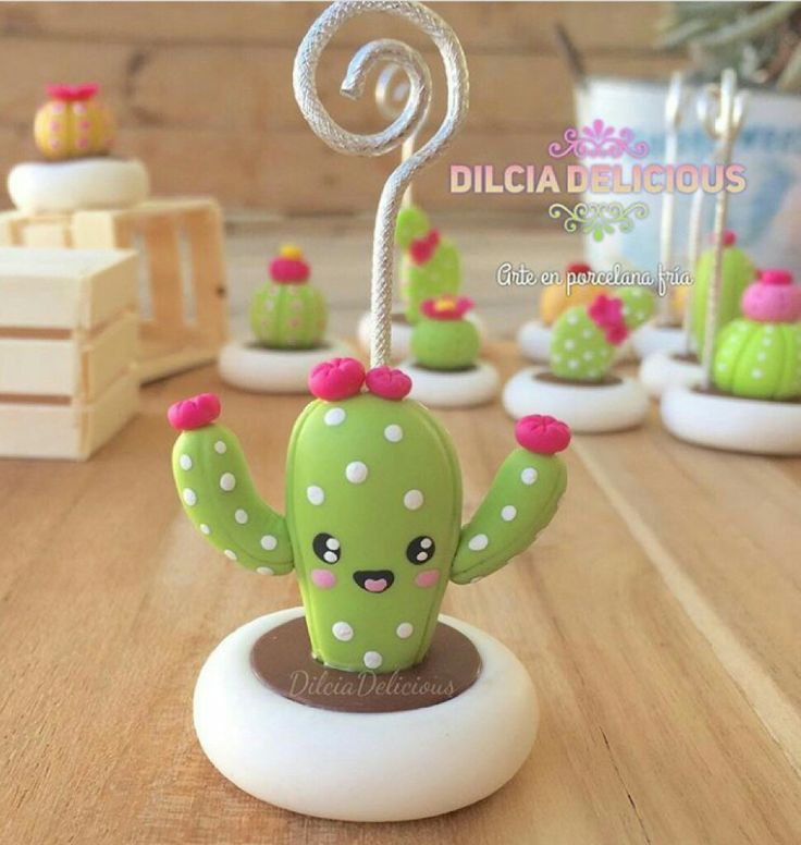 small cactus figurines are sitting on a table with other decorations in the background