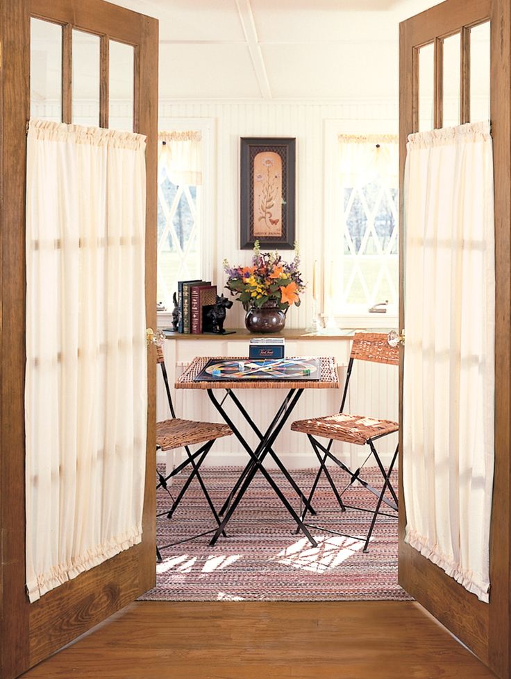 an open door leading to a dining room with two chairs and a table in it