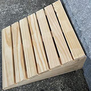 a wooden bench sitting on the ground next to a cement area with some wood planks