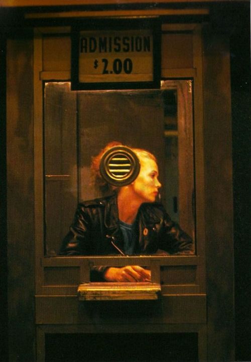 a woman with headphones on looking through a window at the sign for robinson's