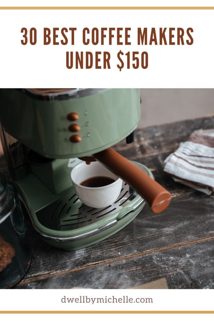 a green coffee maker sitting on top of a wooden table next to a cup of coffee