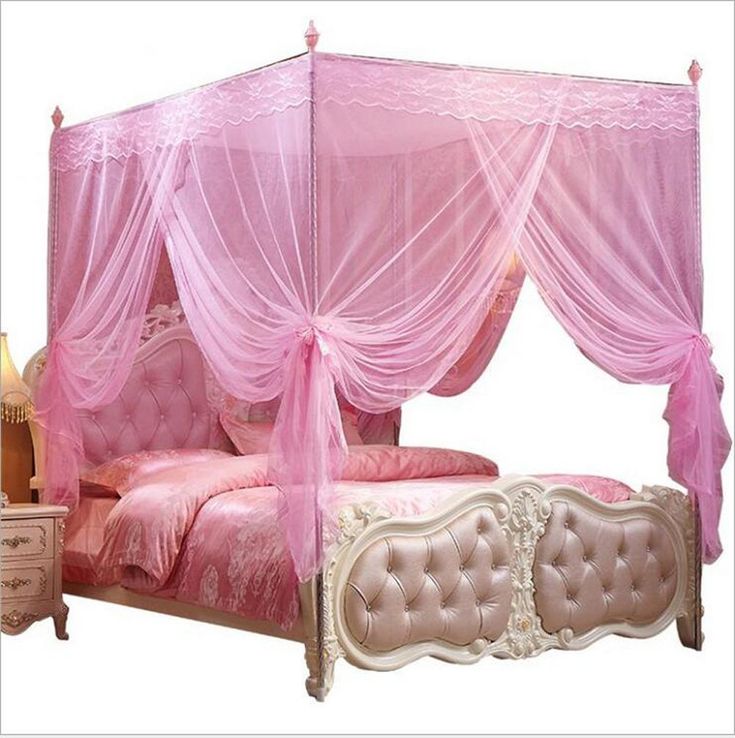 a pink canopy bed sitting next to a night stand