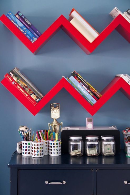 a desk with two bookshelves and other items on top of the shelves in front of it