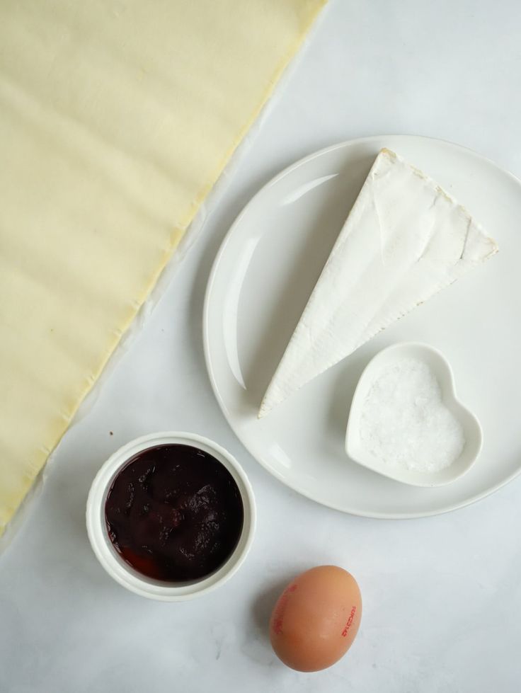 an egg, cheese and sauce on a plate next to a piece of paper towel