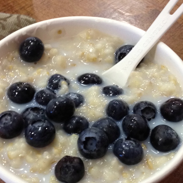 a bowl of oatmeal with blueberries and milk