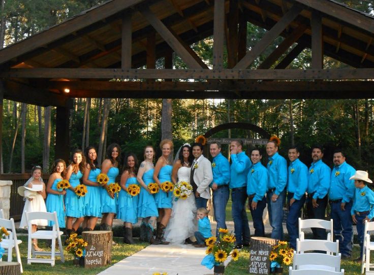 a group of people standing in front of a gazebo with sunflowers on it